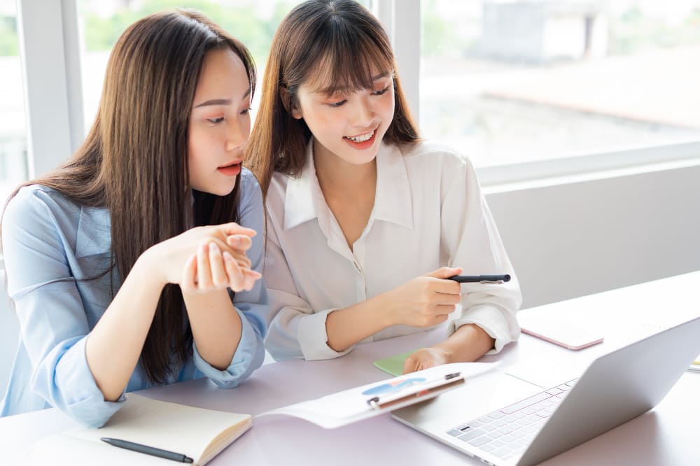 2 workers discussing payroll services in office setting