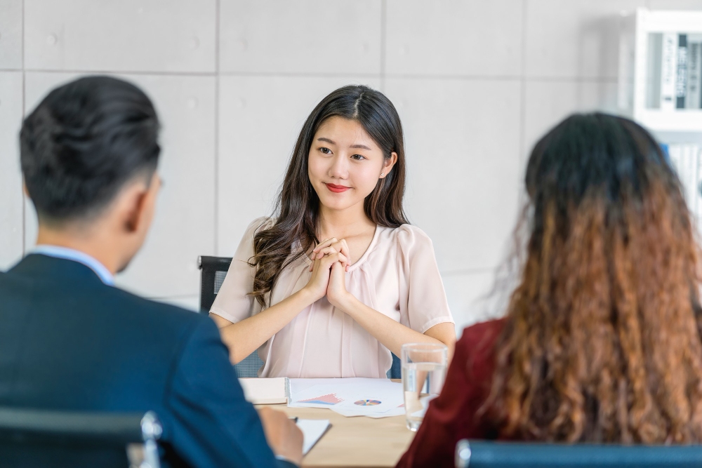young asian woman graduate interviewing with two managers with positive emotions in dream job recruitment process from job seeker candidate with tough interview questions