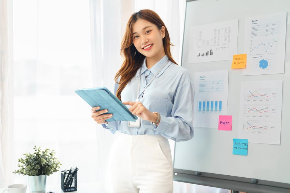 A consultant posing for the RPO service next to a white board displaying benefits and growth of using RPO service