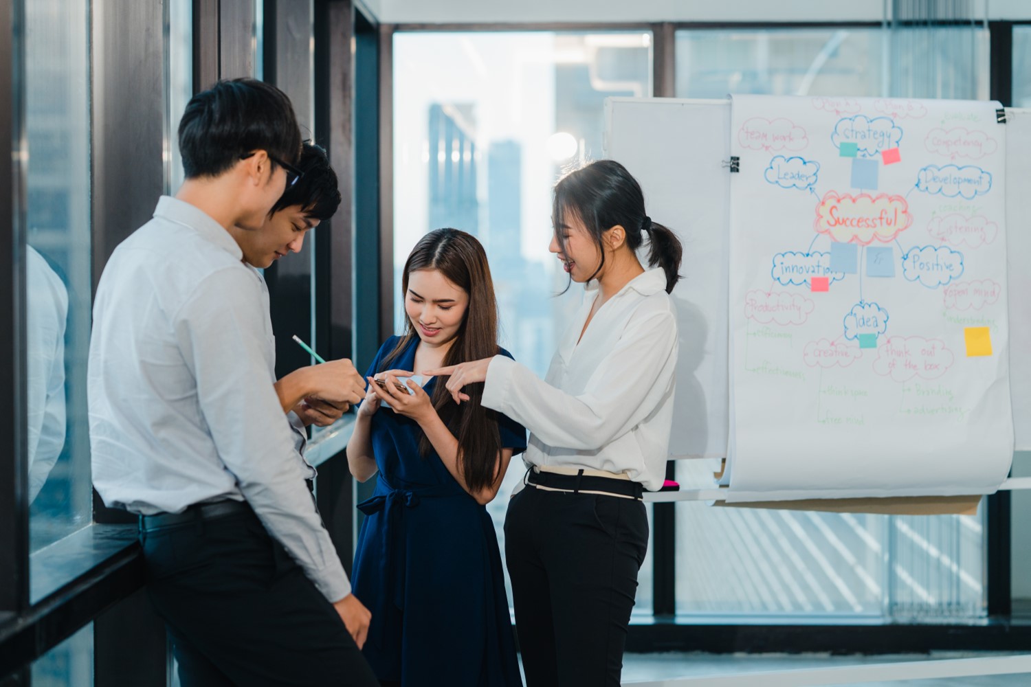 Mixed white-collar workers including EOR employees discuss project scope of work daily tasks in an EOR services provider company office city building