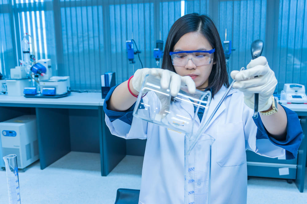 Nhà khoa học nữ trộn hóa chất bằng máy lắc trước khi thí nghiệm